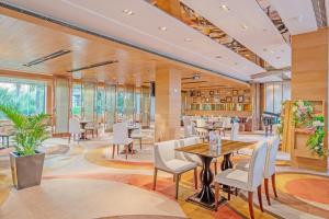 a dining room with tables and chairs and windows at Mission Hills Hotel Resorts Shenzhen in Bao'an