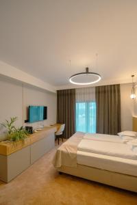 Dormitorio con cama, escritorio y TV en Crama Jelna Resort & Spa, en Orheiu Bistriţei