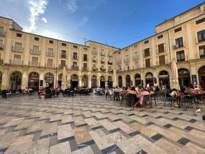 a group of people sitting at tables in front of a building at Piso en el centro de Alcoy para sentirte en casa in Alcoy