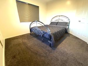 1 dormitorio con 1 cama en una habitación con ventana en Luxury 5beds and 5bedroom en Lower Hutt