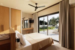 sypialnia z łóżkiem i przesuwnymi szklanymi drzwiami w obiekcie Paloubi Estate w mieście Sinarádes
