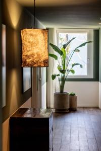 a living room with a lamp and a potted plant at Lu. b&b in Cervia