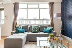 a living room with a gray couch and a glass table at Central Located Apartment in City of London - Farringdon Station in London