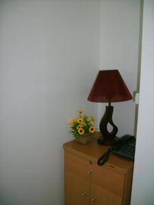 a lamp on top of a dresser with a flower arrangement at Keerawadee Two Bedroom House 