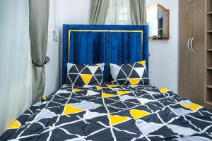 a bed with a blue headboard in a bedroom at Lakeview 2-Bed-Apt With Amazing Views In Every Direction in Amuwo