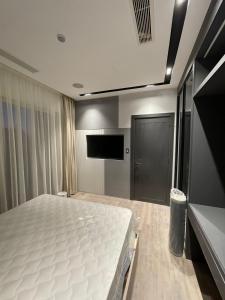 a bedroom with a bed and a flat screen tv at الداون تاون العلمين الجديده خلف الابراج El Down Town New El Alamaein in El Alamein