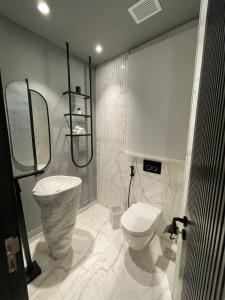 a white bathroom with a toilet and a shower at الداون تاون العلمين الجديده خلف الابراج El Down Town New El Alamaein in El Alamein