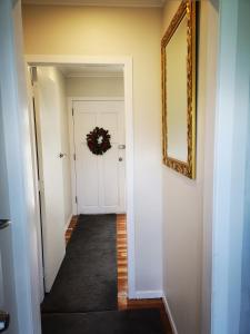 a hallway with a door and a wreath on the wall at Cheerful 4 Bedroom Holiday Home (Sleeps 7) in Rotorua