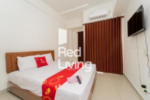 - une chambre avec un lit et une télévision dans l'établissement RedLiving Apartemen Sayana - Sentra Jaya, à Bekasi