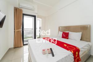 - une chambre avec un grand lit et une fenêtre dans l'établissement RedLiving Apartemen Sayana - Sentra Jaya, à Bekasi