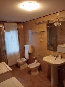 een badkamer met een toilet, een wastafel en een spiegel bij Appartamento Malcontenta in Mira