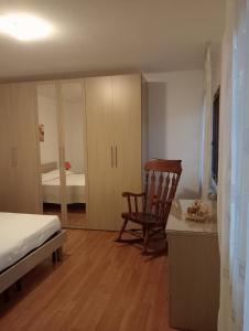 een slaapkamer met een bed, een stoel en een bureau bij Appartamento Malcontenta in Mira