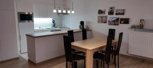 a kitchen with a wooden table and black chairs at Koksijde Gabbiano 104 en parking in Koksijde