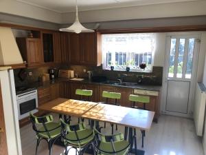 a kitchen with a wooden table and green chairs at Zack's Grande in Athens