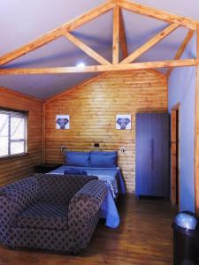 1 dormitorio con 1 cama y 1 sofá en una habitación en ZUCH Accommodation at Pafuri Self Catering - Guest Cabin, en Polokwane