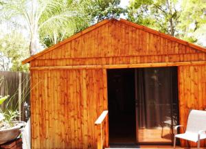 ZUCH Accommodation at Pafuri Self Catering - Guest Cabin في بولوكوان: سقيفة خشبية مع نافذة في الفناء