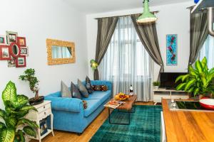 a living room with a blue couch and a table at MySuite Istanbul Cihangir in Istanbul