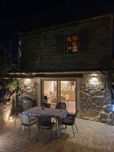 una mesa y sillas en un patio por la noche en Charmantes Ferienhaus mit Pool und Garten-Villa Šterna II, en Kaštelir