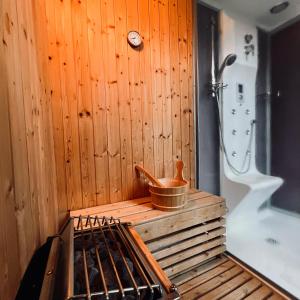 baño con bañera y pared de madera en * La Maisonette * avec Sauna & Hammam privatifs, en Nevers