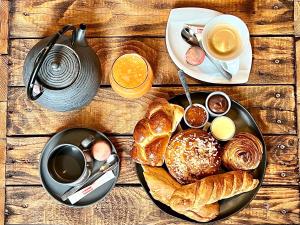 una mesa con una bandeja de alimentos para el desayuno y café en * La Maisonette * avec Sauna & Hammam privatifs, en Nevers