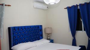 a bed with a blue headboard in a room at BALCONYN 2 SEGURIDAD 24h in La Guáyiga