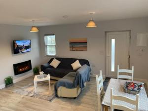 ein Wohnzimmer mit einem Sofa und einem Kamin in der Unterkunft Tadgh's Cottage in Ennis