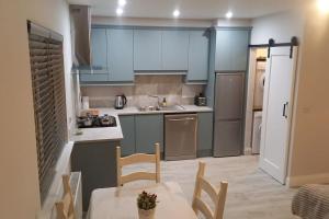 a kitchen with blue cabinets and a table and chairs at Tadgh's Cottage in Ennis