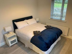 a bedroom with a large bed with two hats on it at Tadgh's Cottage in Ennis