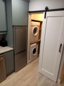 porta aperta a una cucina con lavatrici e asciugatrici di Tadgh's Cottage a Ennis