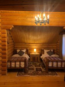 una camera con 2 letti in una baita di tronchi di Kecharis Hotel and Resort a Tsaghkadzor
