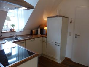 eine Küche mit einer Spüle und einem weißen Kühlschrank in der Unterkunft WERTS HOF FerienWohnen in Rauschenberg