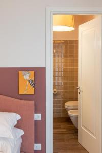 a bedroom with a bed and a bathroom with a toilet at Lu. b&b in Cervia