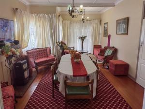 Sibahlenomhlambi Guesthouse في سبيرنغز: غرفة معيشة مع طاولة وكراسي