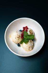 a white plate with ice cream with berries and mint at Crama Jelna Resort & Spa in Orheiu Bistriţei +79 photos