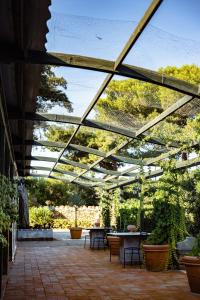 a glass roofed patio with tables and plants at Giardino dell'impossibile di Antonino Campo in Favignana