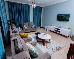Sala de estar con 2 sofás y mesa en The Mbuya Residence en Kampala