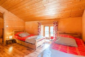 two beds in a room with wooden walls at Gîte des Cascades in Sixt