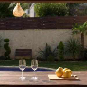 een tafel met twee wijnglazen en een servet bij Nicole Villa, an Enchanted Gem, By ThinkVilla in Embrósneros