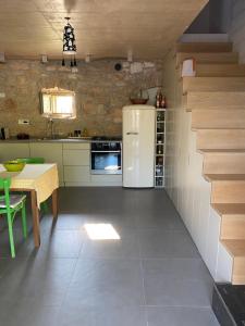 cocina con mesa y nevera blanca en Charmantes Ferienhaus mit Pool und Garten-Villa Šterna II, en Kaštelir