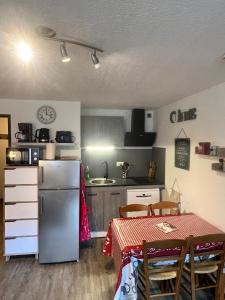 Il comprend une cuisine équipée d'un réfrigérateur et d'une table avec des chaises. dans l'établissement Appt T2 4 pers Saint Lary centre Village Parking, à Saint-Lary-Soulan