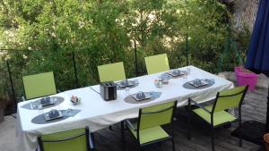 a white table with green chairs on a patio at La Bouillarde in Suze