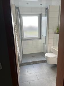 La salle de bains est pourvue d'une douche, de toilettes et d'une fenêtre. dans l'établissement Landgasthaus Lenniger, à Büren