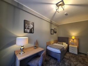 ein Schlafzimmer mit einem Bett, einem Tisch und einer Lampe in der Unterkunft Landgasthaus Lenniger in Büren