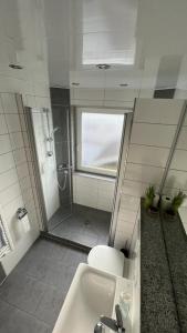 a bathroom with a shower and a sink and a toilet at Landgasthaus Lenniger in Büren