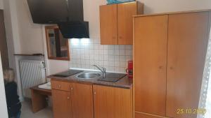 a kitchen with wooden cabinets and a sink at Haus Despina in Sarti