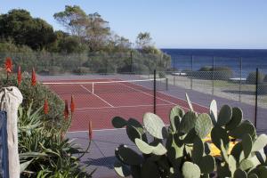 a tennis court with a tennis court at Les Bungalows de Figha in Tarcu