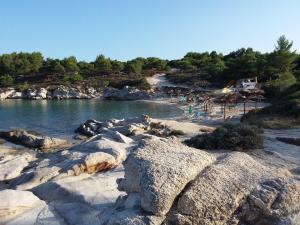 a beach with rocks and people on the water at Haus Despina in Sarti