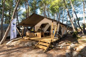 a large tent with a picnic table in the woods at Easyatent Safari tent Aminess Maravea in Novigrad Istria