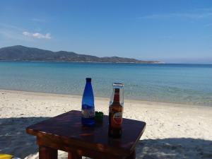 two bottles of beer sitting on a table on the beach at Haus Despina in Sarti