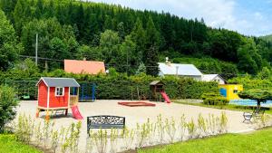 un parque infantil con una casa roja en Hotel Slatina en Lipova Lazne